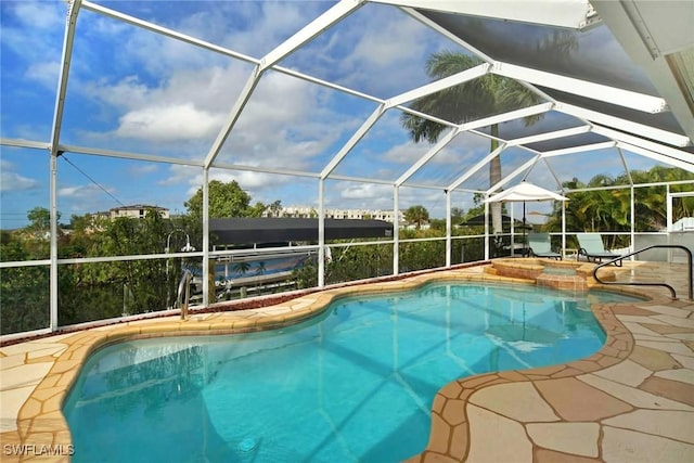 view of swimming pool featuring a lanai, a patio area, and an in ground hot tub