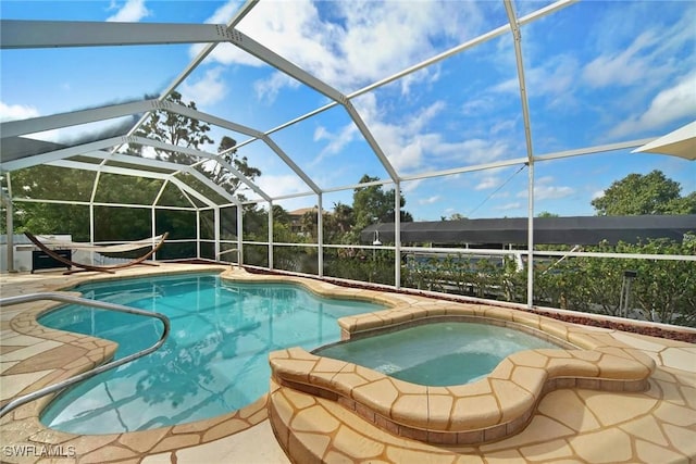 view of pool featuring glass enclosure and an in ground hot tub