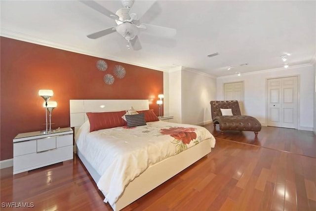 bedroom with ceiling fan, dark hardwood / wood-style floors, ornamental molding, and a closet