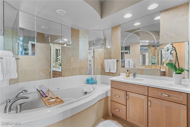 12701 Mastique Beach Blvd Unit 1601, Fort Myers, FL 33908 - bathroom with recessed lighting, tile walls, a garden tub, and vanity