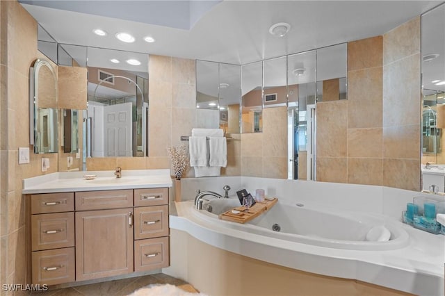 bathroom featuring tile walls, a washtub, tile patterned floors, and vanity