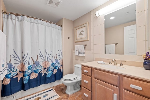 bathroom featuring tile walls, vanity, and toilet