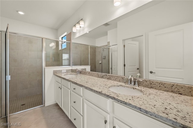 bathroom featuring vanity, tile patterned floors, and a shower with shower door