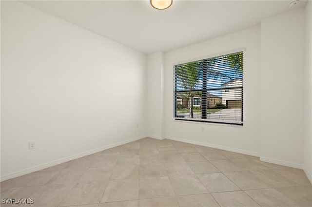 empty room featuring light tile patterned flooring and a healthy amount of sunlight