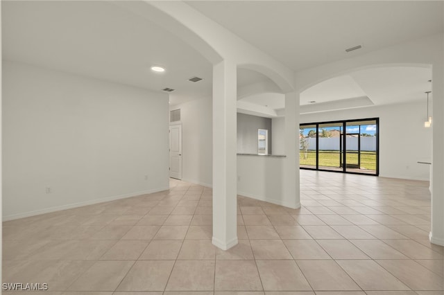 tiled empty room with a tray ceiling