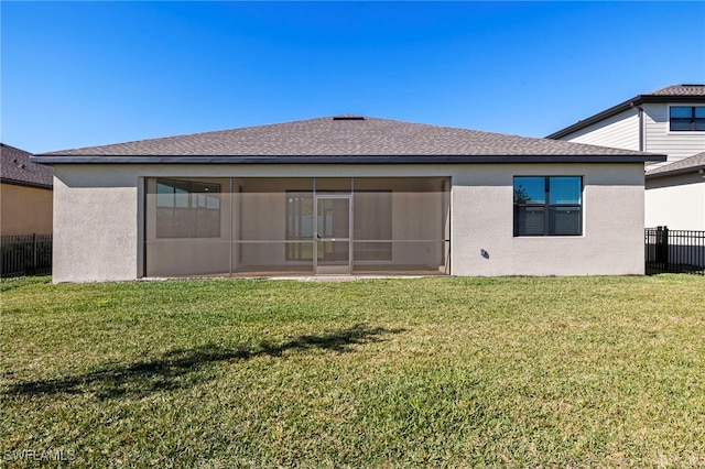 rear view of house with a lawn and a sunroom