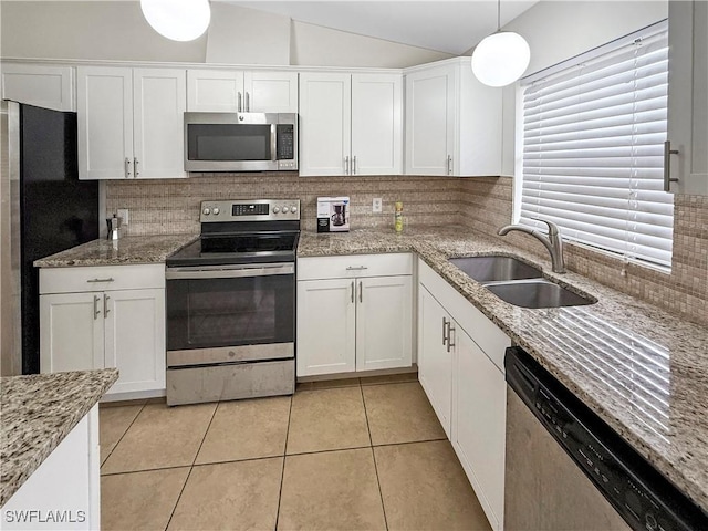 kitchen featuring appliances with stainless steel finishes, white cabinetry, tasteful backsplash, sink, and hanging light fixtures