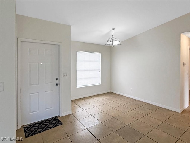 tiled entrance foyer with an inviting chandelier