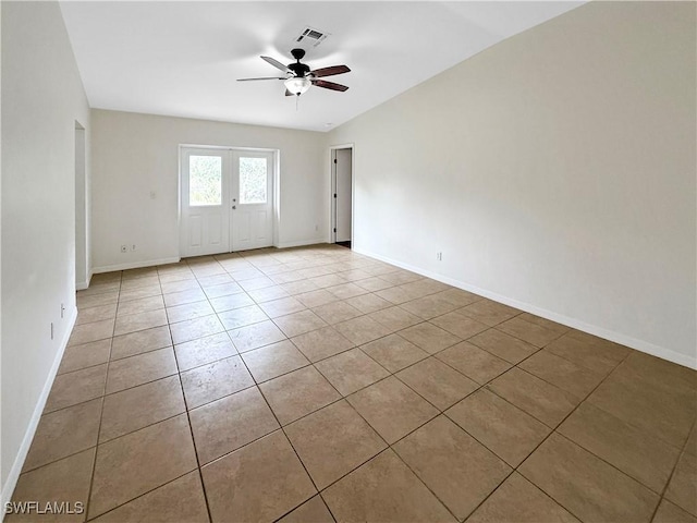 tiled spare room with ceiling fan and french doors