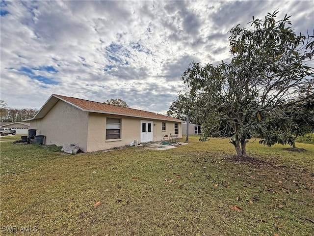 rear view of property featuring a yard and a patio