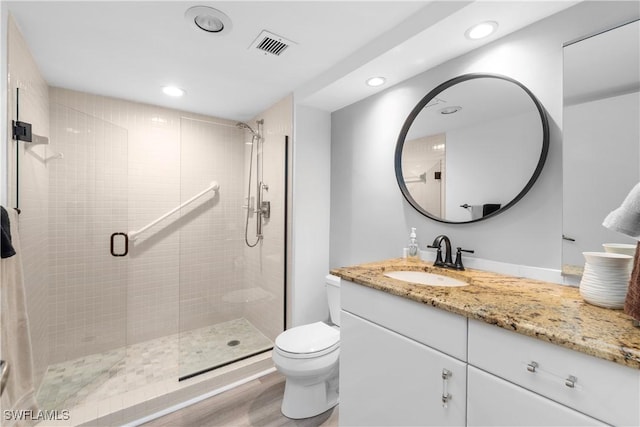 bathroom with wood-type flooring, vanity, toilet, and an enclosed shower