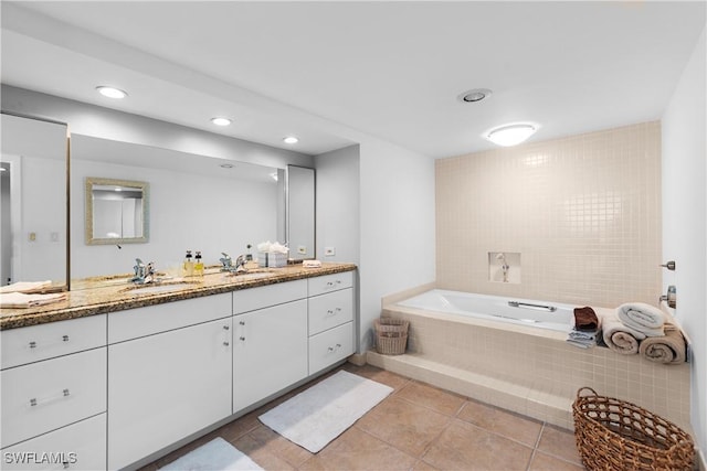 bathroom with tile patterned floors, tiled bath, and vanity