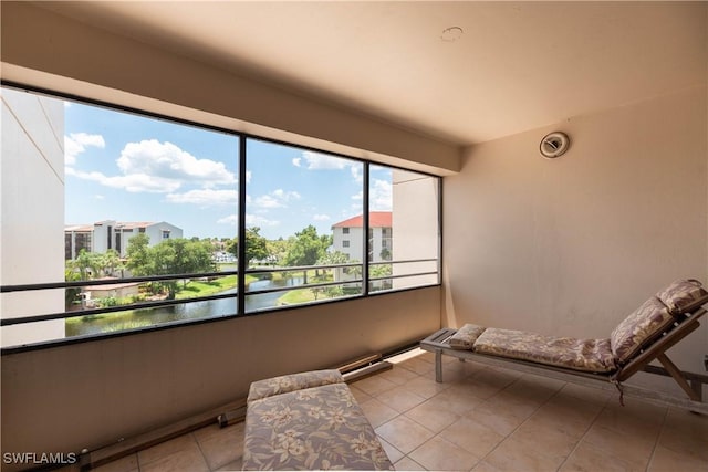 sitting room featuring light tile patterned flooring and a water view