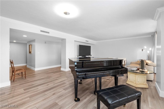 miscellaneous room with crown molding and light hardwood / wood-style floors