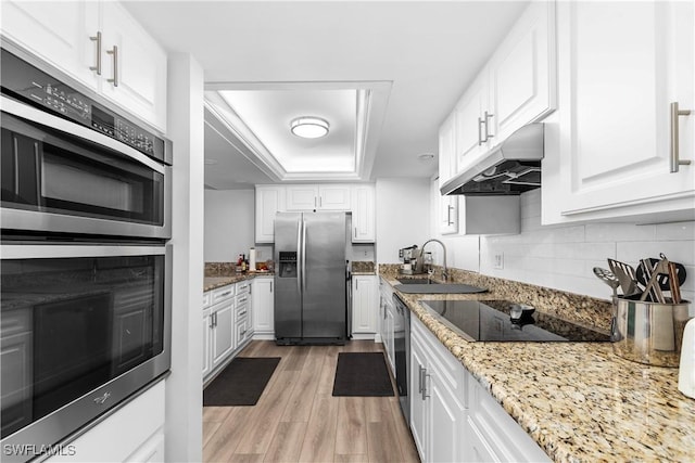 kitchen with appliances with stainless steel finishes, white cabinetry, and light stone counters