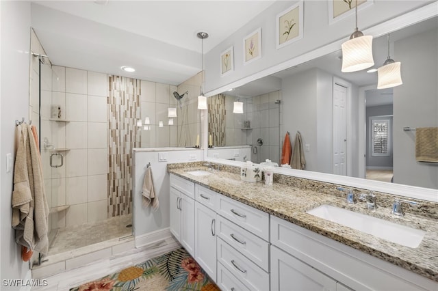 full bath with double vanity, a stall shower, and a sink