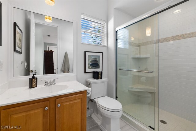 bathroom with an enclosed shower, vanity, and toilet