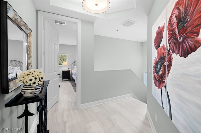 hallway with baseboards and visible vents