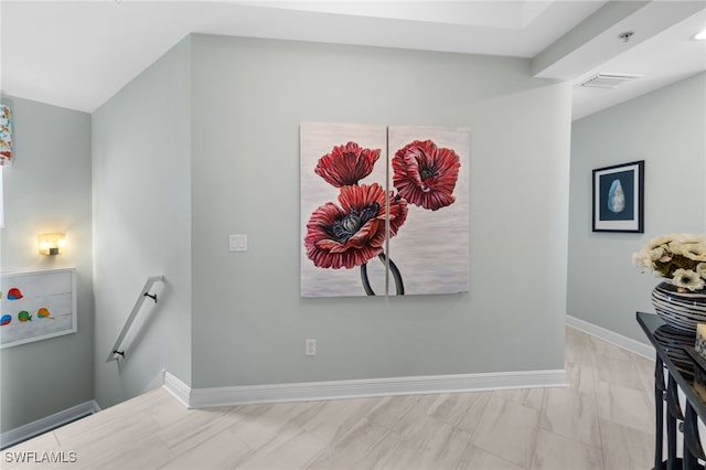 interior space with visible vents, an upstairs landing, and baseboards