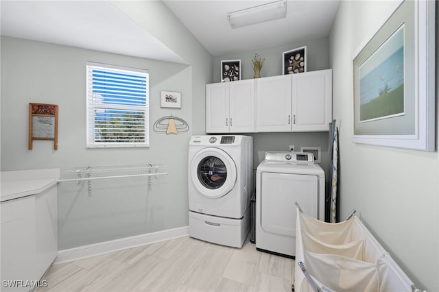 laundry room with cabinets and washer and clothes dryer