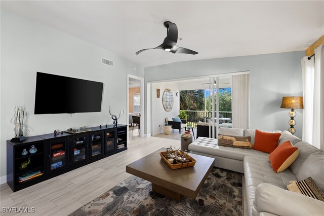 living room with ceiling fan and light hardwood / wood-style flooring