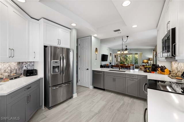 kitchen featuring appliances with stainless steel finishes, gray cabinetry, white cabinets, and sink