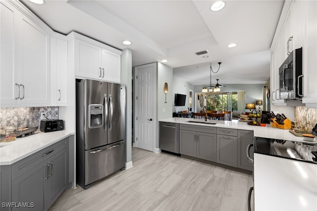 kitchen with white cabinetry, stainless steel appliances, light countertops, and gray cabinetry