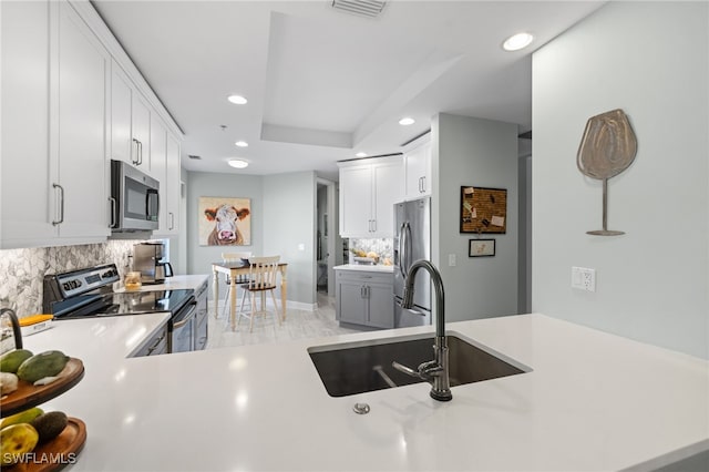 kitchen with sink, stainless steel appliances, white cabinets, and tasteful backsplash