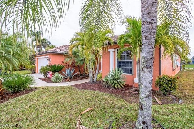 view of front of home with a garage and a front lawn