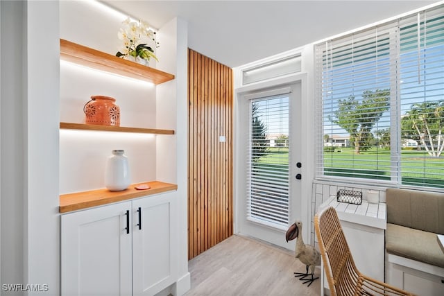 doorway featuring built in desk, light hardwood / wood-style floors, and a chandelier