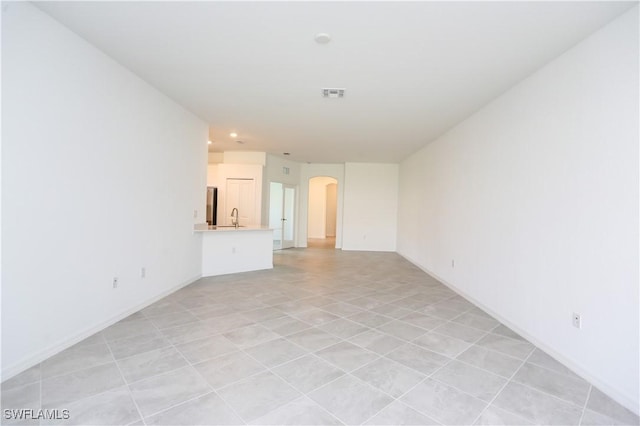 unfurnished living room featuring sink