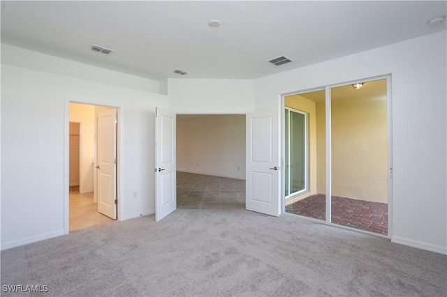 unfurnished bedroom with a closet and light carpet