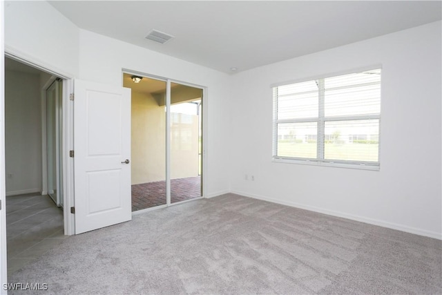 unfurnished bedroom featuring a closet and light carpet