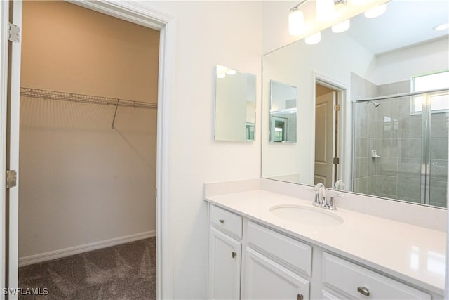 bathroom with a shower with door and vanity