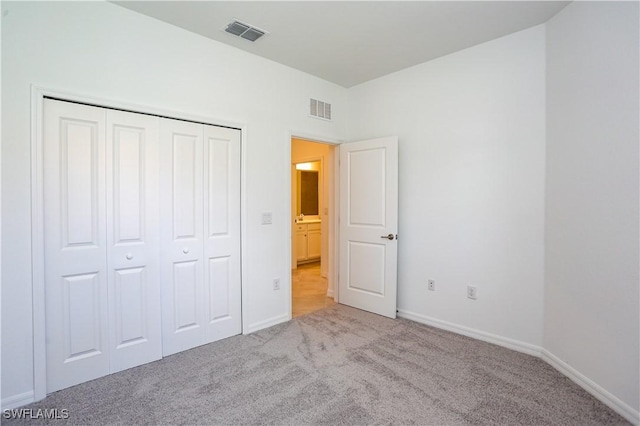 unfurnished bedroom featuring a closet and light carpet