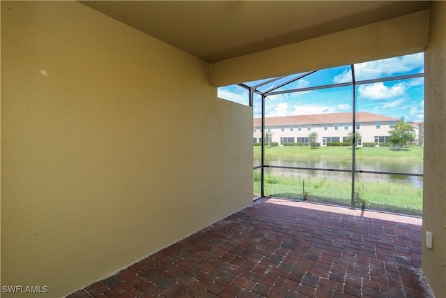 view of patio with glass enclosure and a water view