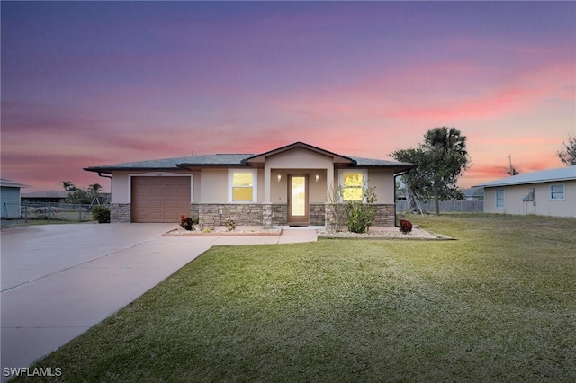 view of front of home with a garage and a yard