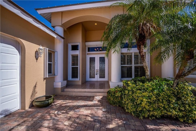 property entrance featuring a garage and french doors