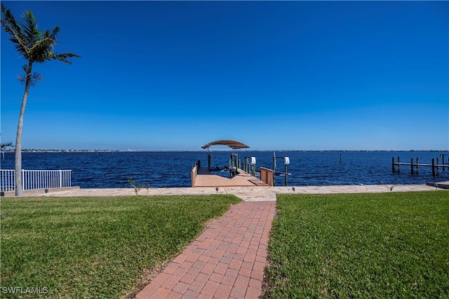 view of dock featuring a lawn and a water view