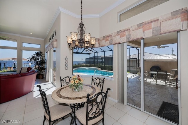 tiled dining space with ceiling fan, ornamental molding, and a wealth of natural light