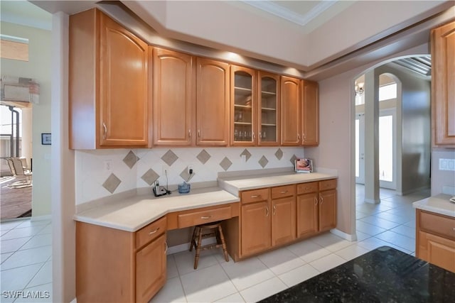 kitchen with crown molding, light tile patterned floors, and backsplash