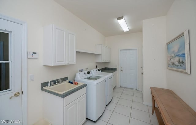 washroom featuring cabinets, sink, light tile patterned floors, and washer and clothes dryer