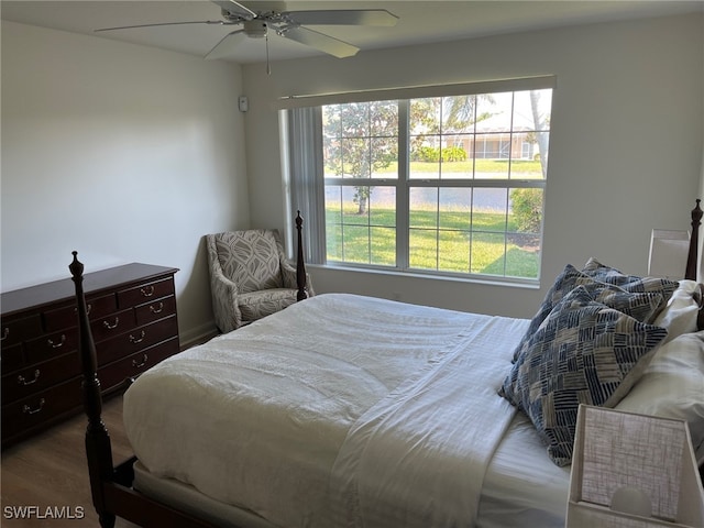 bedroom featuring ceiling fan, multiple windows, and hardwood / wood-style flooring