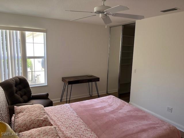 bedroom featuring ceiling fan, a closet, and multiple windows