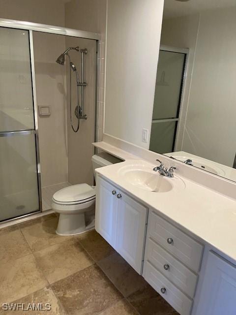 bathroom with toilet, vanity, and an enclosed shower