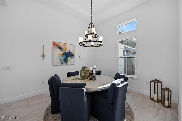 dining room with light hardwood / wood-style floors and a notable chandelier