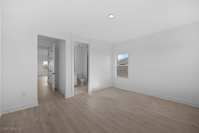 spare room with light wood-type flooring and a healthy amount of sunlight