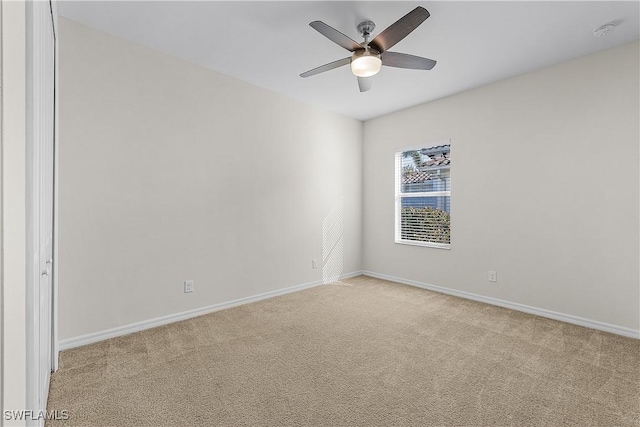 unfurnished room with light colored carpet and ceiling fan