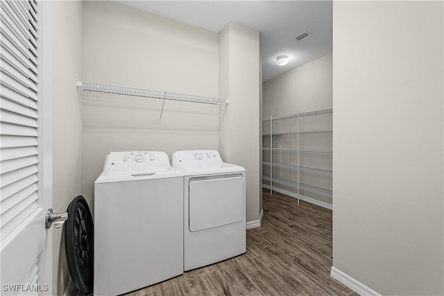 laundry room with independent washer and dryer and hardwood / wood-style flooring