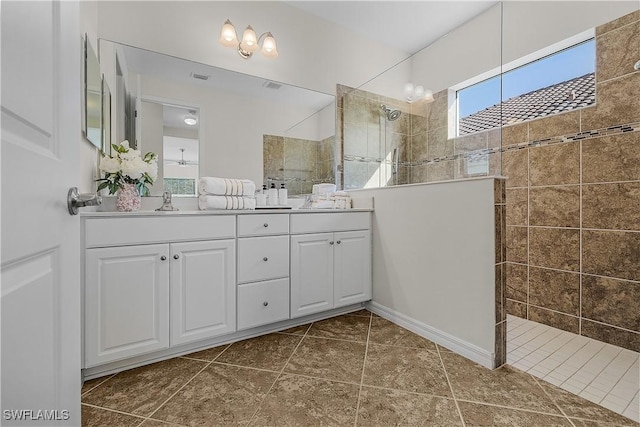 bathroom featuring vanity, tile patterned floors, and tiled shower